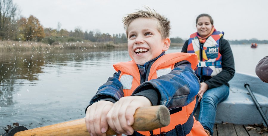Ein Kind und eine Frau rudern auf einem See.